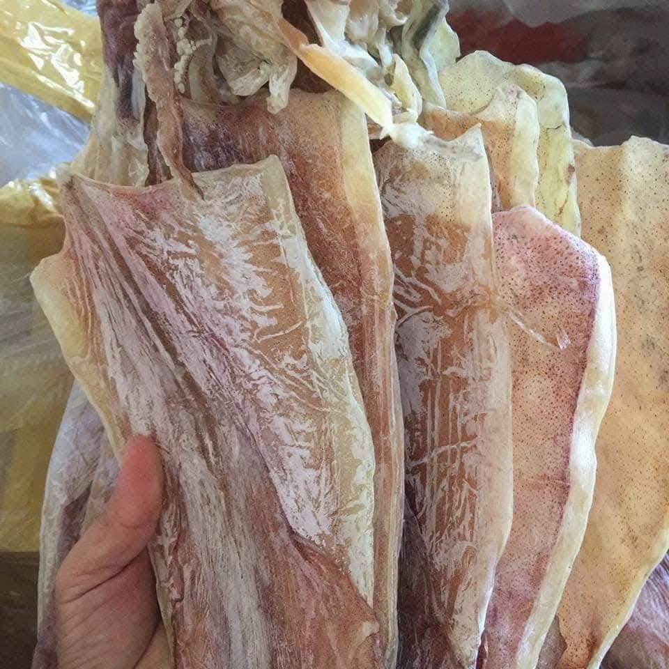 Tay cầm những con mực khô to